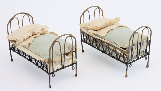 Two Ladies Guild Beds: British, circa 1850's, the fine quality and thin tubular metal and wire construction of these well dressed beds are almost certainly the work of the guild's toy makers group that was primarily made up