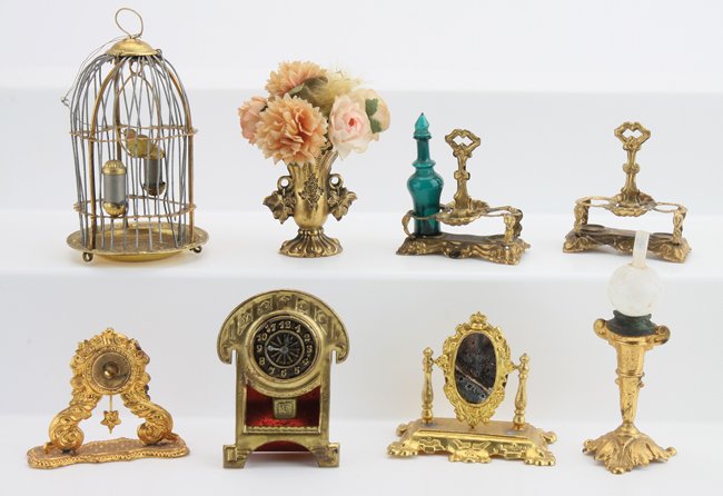 Ormolu Dolls' House Miniatures: Erhard & Sohne faux oil lamp (darkening around base of globe), 2 clocks (1 missing face), dresser mirror (wear and crack to mirror), 2 cruet stands (only 1 cruet), vase and birdcage (bars have been re