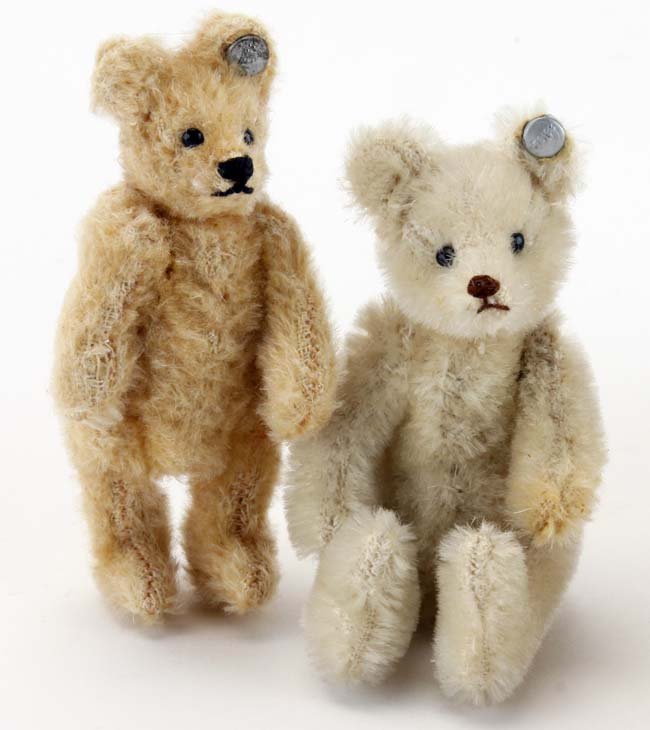 Two Small Steiff Bears: miniature jointed bears both with button eyes, sewn noses and mouths and retaining ear buttons; smaller is a golden honey tone with hump back and other is white/off white (very slight discoloring to l