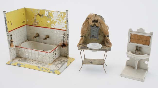 German Miniature Bathroom Fixtures: painted and embossed tin bath tub wall with water reservoirs (serious paint flaking), painted tin wash stand with original net draping and wood and cast soft metal sink with rear wall and base tub sur