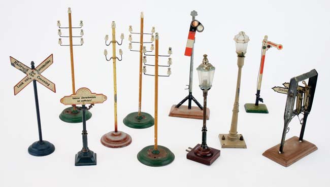 European Trackside Accessories: mostly painted tin grouping by Marklin etc. includes 4 telegraph poles, 2 street lamps, 2 semaphores and 2 German signage directionals and crossing sign in English poles 10" t.