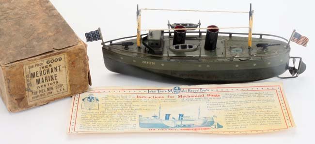 Ives Merchant Marine with Original Box: painted tin clockwork freighter retaining masts, 2 flags and cast iron wind key in original box with label '6009 Ives Merchant Marine Toys' and scarce instruction sheet boat 10.25" l.