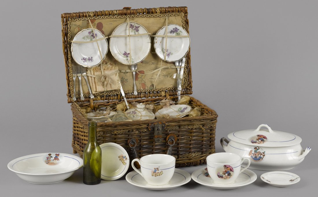 Child's nine-piece porcelain picnic set with th: Child's nine-piece porcelain picnic set with the original woven basket, a wine bottle, napkins, etc., 5 1/2'' h., 12'' w., together with eight pieces of children's dishes with various play scenes, cov
