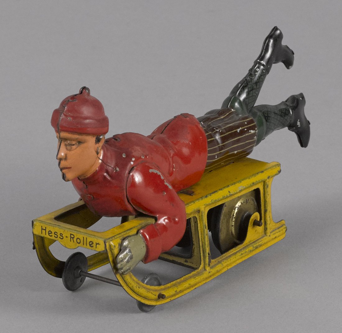 J. L. Hess tin lithograph wind-up boy on sled, (1 of 2)