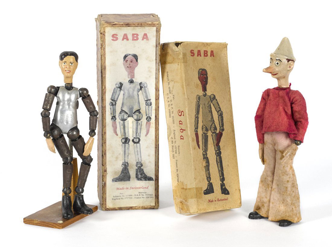 Two Swiss Bucherer metal ball jointed Pinocchio: Two Swiss Bucherer metal ball jointed Pinocchio Saba figures, in their original boxes, to include Pinocchio, 8 1/2'' h., and an undressed figure with a pose booklet, 8'' h.