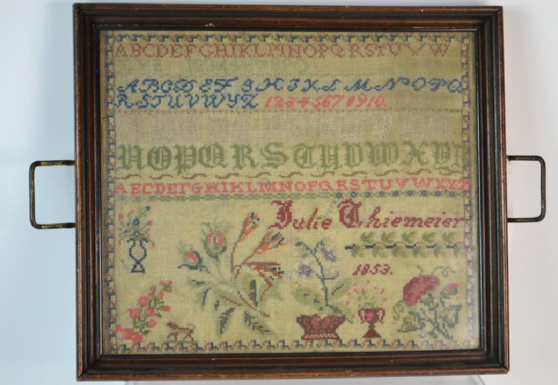 19th Century Needlepoint Sampler: 19th century needlepoint sampler with alphabet, numbers, flora, and a dog. Signed and dated Julie Thiemeier, 1853. Framed: 14â€ x 12â€.
