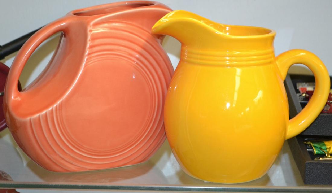 2 Water Pitchers: 2 Water Pitchers (1) Fiesta Ware, and the other is an unmarked pitcher.