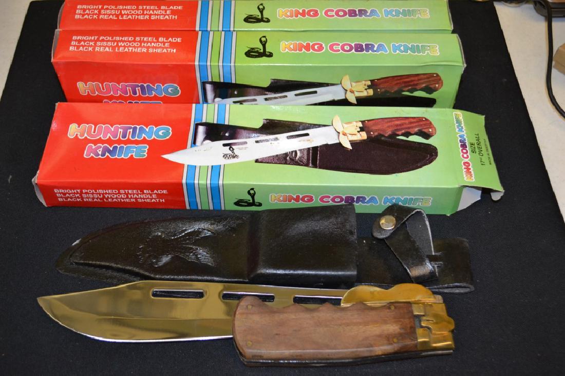 3 King Cobra Hunting Knives in Sheath: 3 King Cobra Hunting Knives with Brass & Wood Handle in Sheath marked Stainless Steel Pakistan. Still in packaging, but some have oxidation from age.