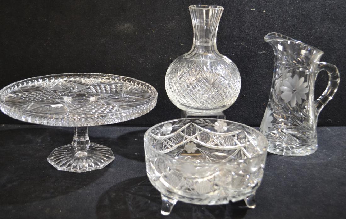 Four Piece Crystal and Cut Glass Lot: Four Piece Crystal and Cut Glass Lot including; crystal cake stand, cut glass carafe, crystal water pitcher, and footed bowl