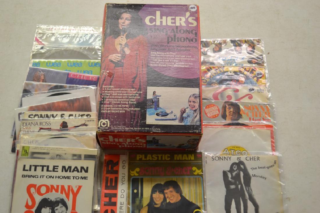 Cher`s Sing-Along Phono 977 Mego Corp: Sonny & Cher - A 1977 Mego Corp `Cher`s sing-along phono` with microphone, amplifier and adaptor in original packaging, along with 30 70s and 80s era 45s including; Plastic Man, Groovy Kind Of Love, L