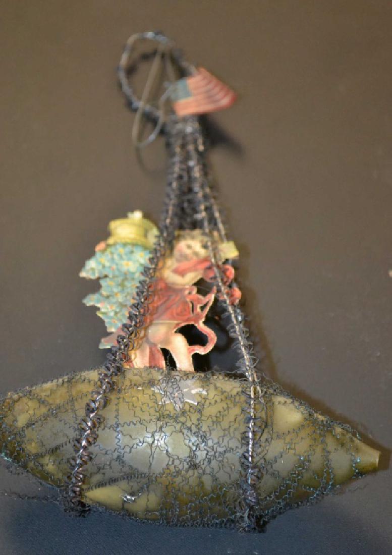 Patriotic Victorian Christmas Ornament: Patriotic Victorian Christmas ornament featuring a glass base with a young woman upending a basket of Bluebells, under a paper American flag, wire wrapped Maypole - glass loss to tail, appx 1/2" inch 