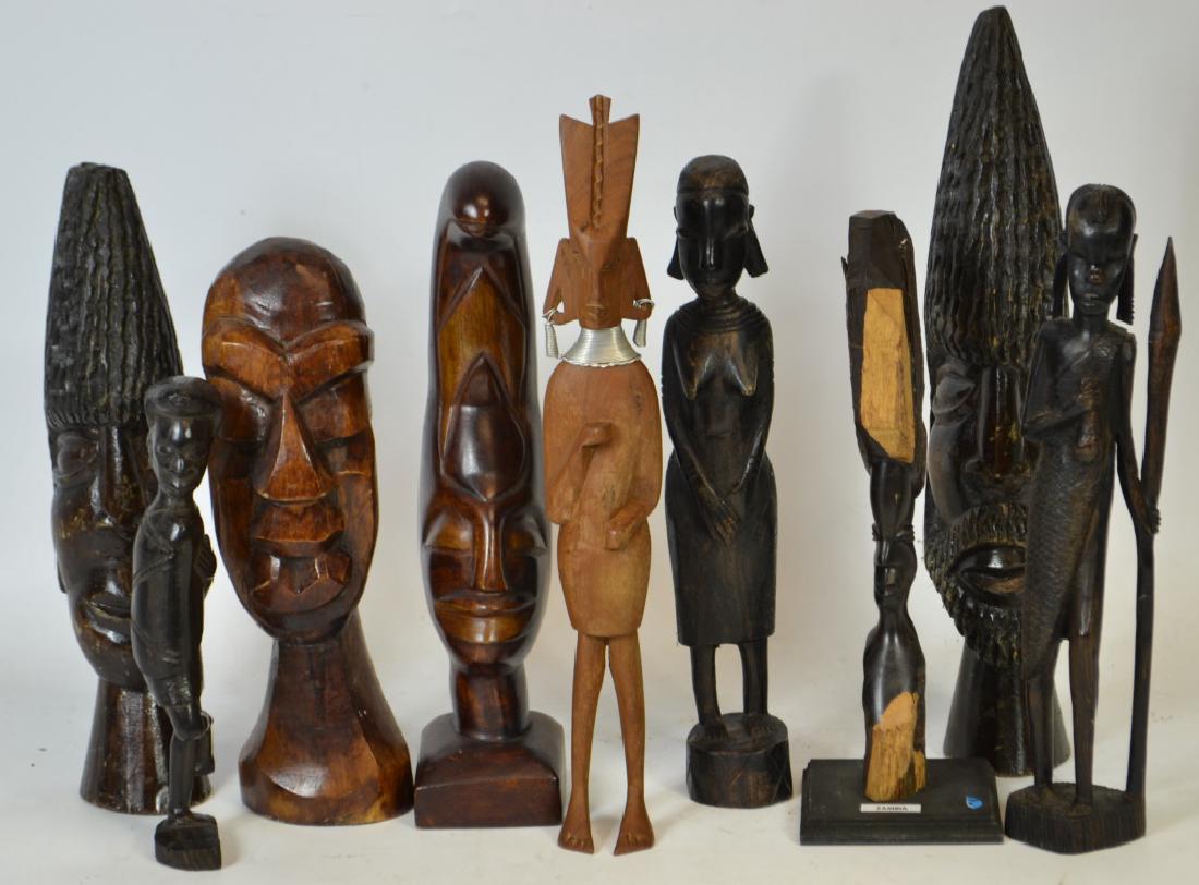 Nine Wooden African Carved Items: African carved items including; two with pointed heads, a carving of a woman that retains the natural wood above and below the carved area marked Zambia, a Zulu man, a Zulu woman, and more