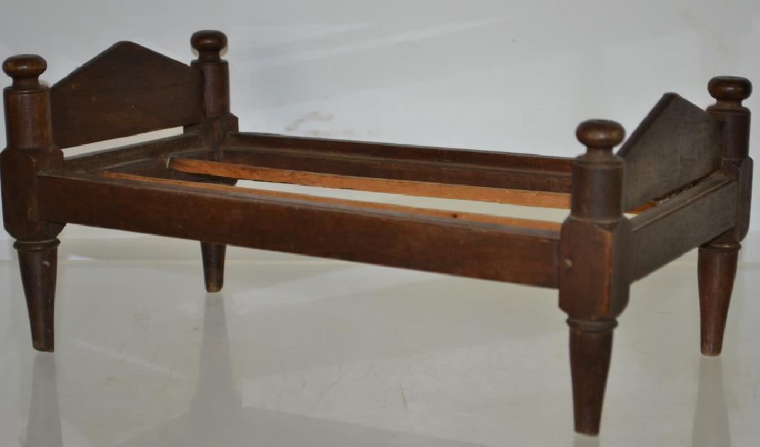 Walnut Miniature Doll Bed Circa. 1890 True to scale: True to scale with blind mortise construction, good turnings and a beaded frame. 6"h x 14"l x 6"w. Good condition with wear to feet consistent with age.