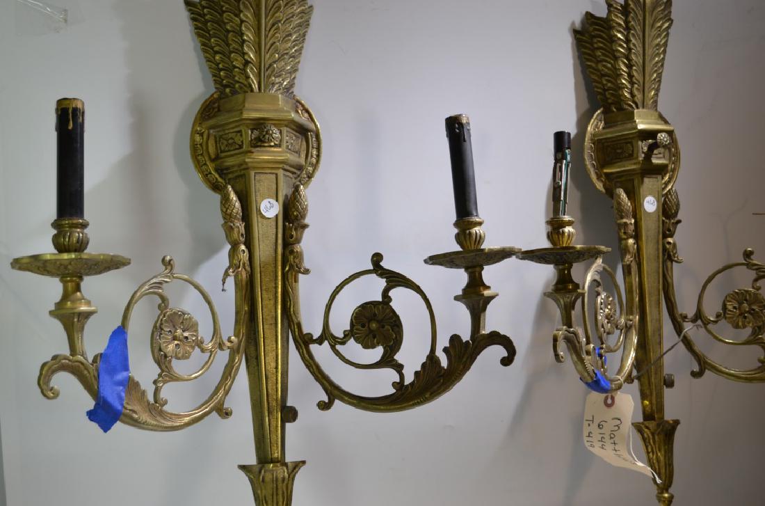 Pair of Ornate Brass Wall Sconces: Sconces each measure approx. 27 1/2"h x 18 1/2" at widest point. They are marked "Lexington" on the on/off switch. One sconce is missing a saucer and a bobeche.