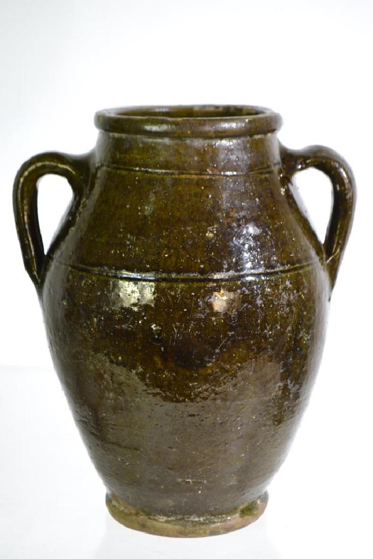 19th Century Redware Vessel: Item measures approx. 11"h. It has 2 well executed handles and a green/black salt glazed surface. It has 1 small chip and waste marks at opening with some roughness. Item has good form and "rings" wel
