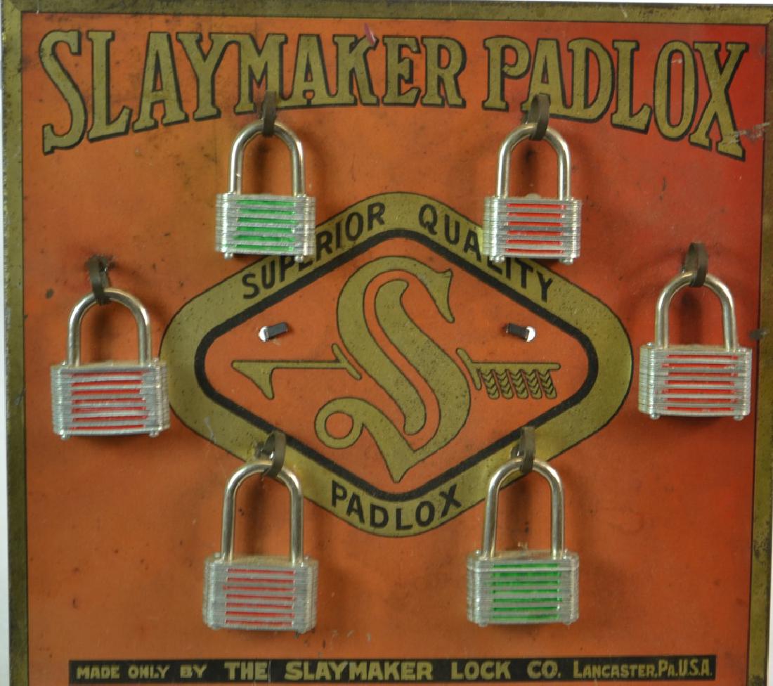 "Slaymaker Padlox" General Store Display: Item measures approx. 9"h x 9"w. It is a tin display which reads "Slaymaker Lock Company Lancaster, PA.". It has good graphics and comes with six locks, keys & key hangers on the back.