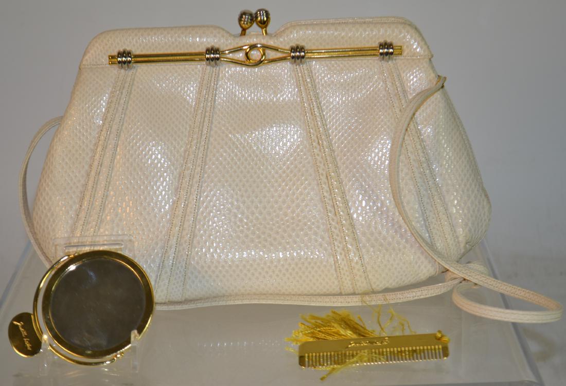 "Judith Leiber" Signed Purse: Item measures approx. 7"h x 10" across. It is white leather with silver and gold accents. Item is marked on the hinge "Made Italy Judith Leiber 1986". The purse also includes a tag on the interior. a