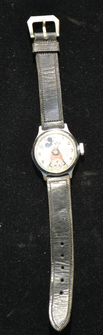 Vintage Ingersoll Mickey Mouse Watch: Watch has a central Mickey with three Mickies around the second hand movement. The second hand is missing. Item is marked "Mickey Mouse Ingersoll Made in the USA".