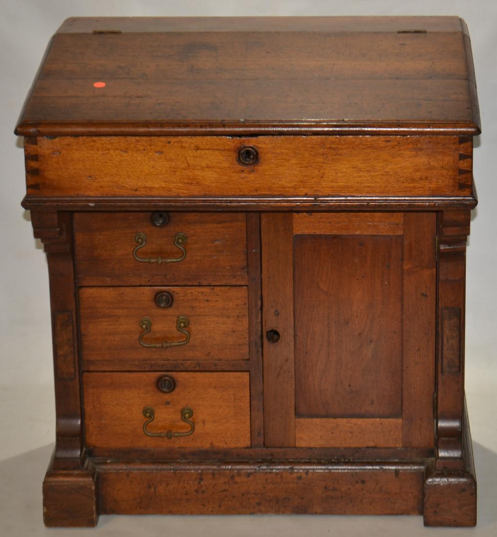 19th C Walnut Davenport from the Blair Estate: Item stands approx. 32"h x 30"w x 22"d. It is solid walnut construction and has a lift top with four interior cubbies. The desk top is hand dove tailed and the base has three drawers and a door. Brass