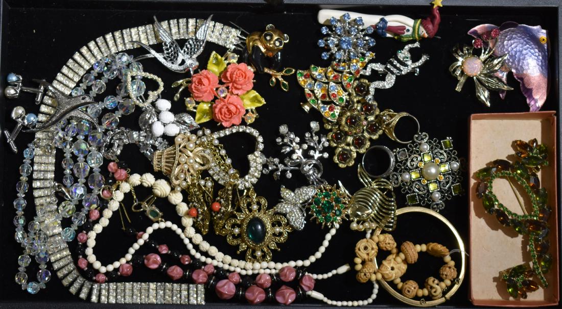 Quality Costume Jewelry: Including a brooch and earring set with multi colored stones, a carved bone bracelet, a large rhinestone necklace, various animal pins, floral pins and a rhinestone bracelet.