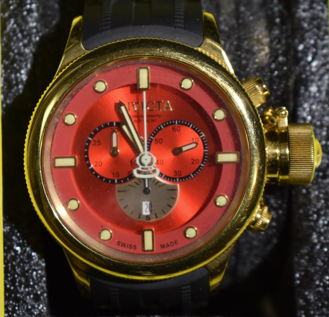 Invicta Chronograph Swiss Diver's Watch: The watch has a red face with a gold tone and black band. It has a 100 meter depth capacity, extra band pieces for sizing and is in the original case with paperwork.