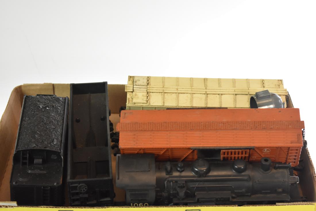 Mixed Lionel Train Grouping: Including a #1060 engine, an unnumbered tender four metal Lionel train cars and a plastic coal car.