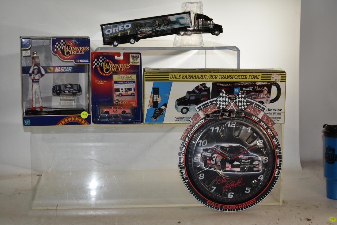 Dale Earnhardt Grouping: Including a Wall clock, two transport vehicles, Pink K-2 car on hang card and a Dale Jr. figure in box with car.