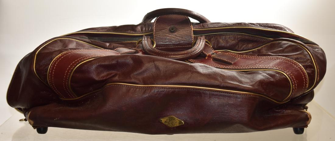 Vintage Leather Gary Player Duffle Bag: Item measures approx. 23" long. It has a burgundy leather exterior, a vinyl interior, two handles and clasps and a tag that reads "Gary Player Pro Line Michael Davis, Inc.".