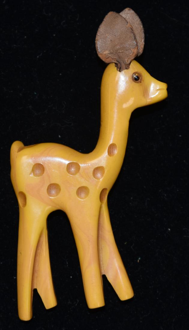 Vintage Bakelite Deer Pin: Item measures approx. 3 1/2"h. It is butterscotch Bakelite with leather ears and a glass eye.