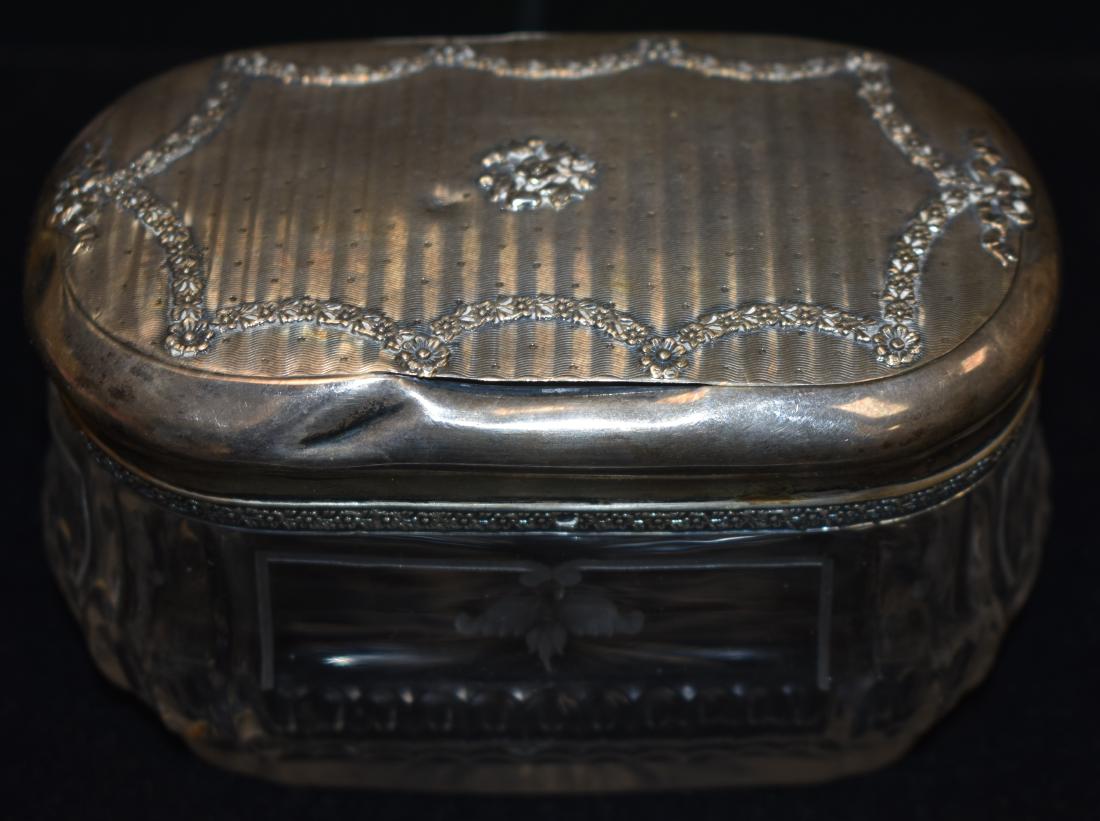 French Sterling and Brass Trinket Box: Item measures approx. 3"h x 5"w .It has a garland design on the lid with a French hallmark and the base is sterling banded. Note: Base has a small dent.