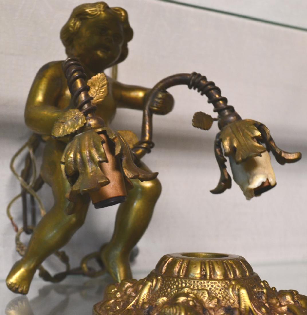 Hanging Brass Putti Lamp: Figure measures approx. 8"h. The Putti figure is holding a vine with two light sockets. Item has the original chain and brass mounting plate. The plate is marked "Made in Spain".