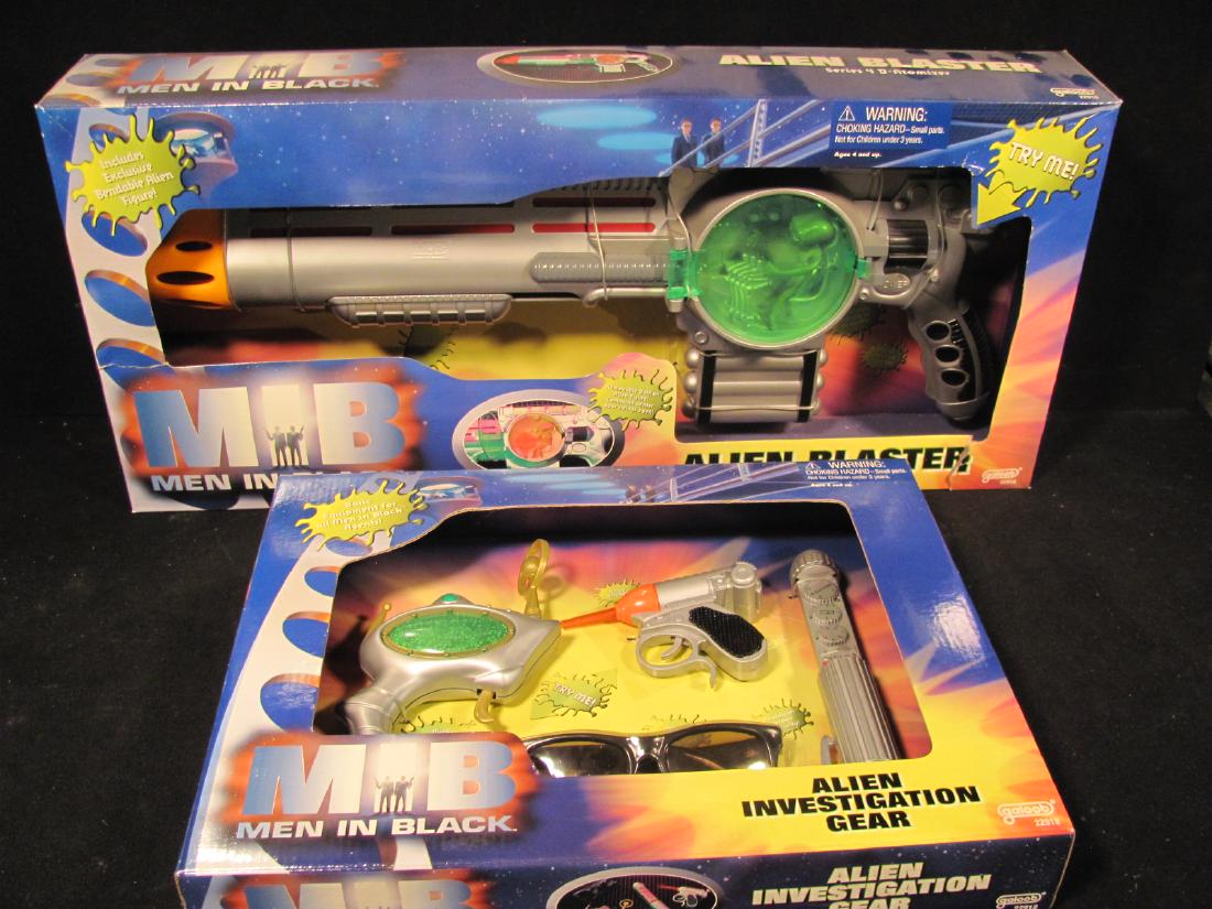 Men In Black toy gun (2)/orig boxes: Two Men In Black gun sets including a (1) Series 4D atomizer with removable balltian alien figure and (2) an alien investigation gear set, unopened in original packaging made by Galoob. Atomizer box h