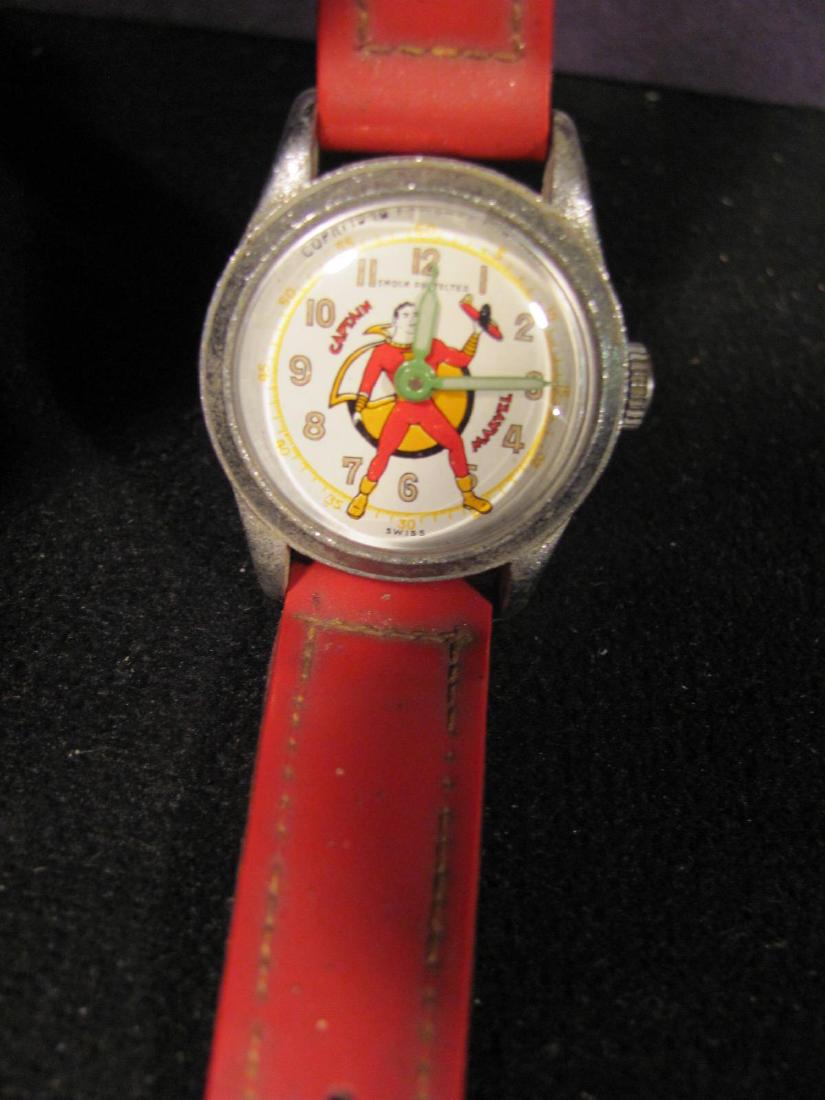 Captain Marvel Watch: Watch face is 1 1/4" in diameter and runs. Face reads "Copr. 1948 Fawcett Pub. Shock Protected Captain Marvel Swiss". Case has some oxidation and clean glass front. Original red band straps with crack