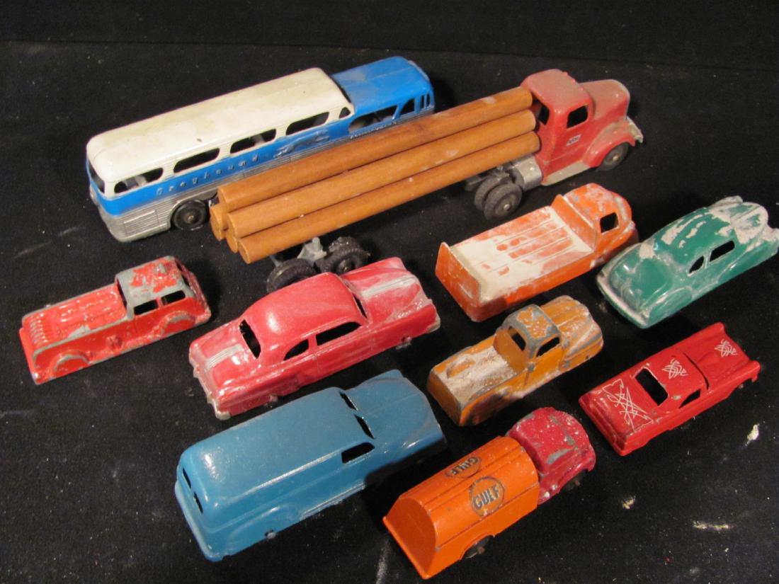 Collection of Tootsietoy Vehicles: Including flatbed, delivery truck, fire engine, Gulf Oil truck, 3 cars, logging truck, and other early Greyhound Bus. All used in train layout and may have fake snow on them. Good condition.