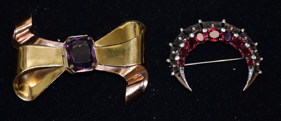 Sterling Trifari and Corot Grouping: "Trifari" Crescent Moon pin in Sterling with red and clear stones. "Corot" Bow pin with large purple stones.