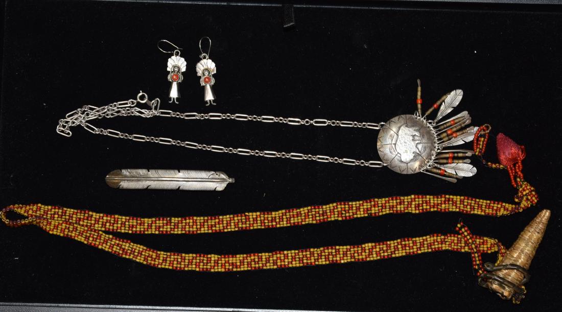 Native American Jewelry Grouping: Sterling buffalo pendant on a chain with feathers, coral and shell fringes, a pair of native chief earrings with coral centers, a sterling feather barrette and a vintage beaded necklace with corn husk