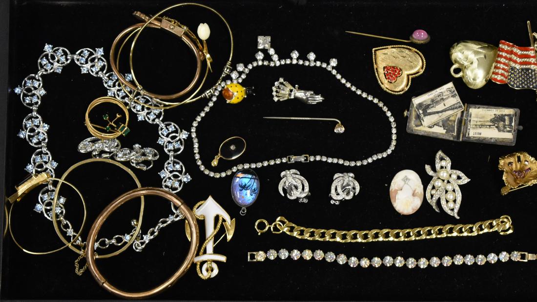 Designer and Costume Jewelry: Including a Victorian pendant/booklet from France, rhinestone clip earrings and pin, a necklace with blue stones and a pair of similar earrings, an anchor pin by Trifari, a lady bug pin, a Victorian s