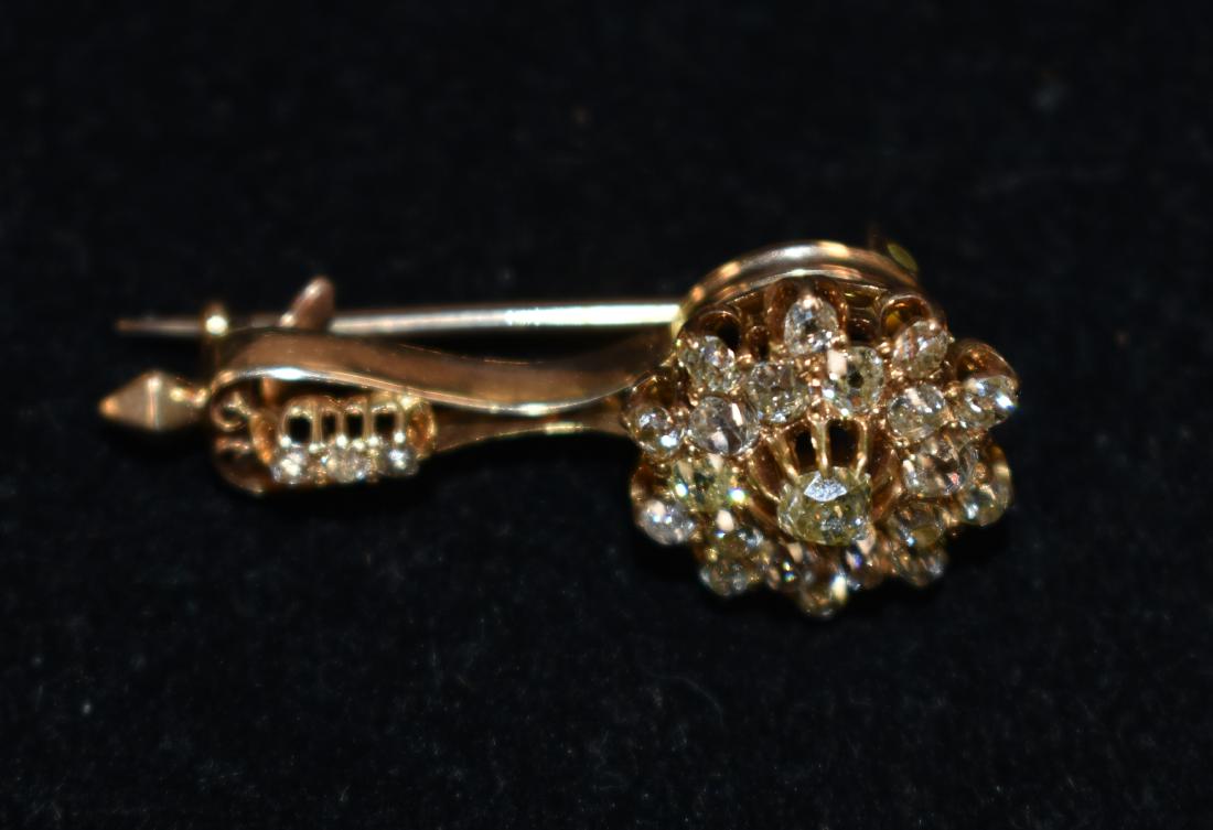 Early 14K Gold Diamond Pendant: Late 19th/early 20th century 14K gold and diamond pendant in the form of a flower with an estimated 3mm center stone surrounded by approx. twenty three smaller diamonds. Item measures approx. 4" in le