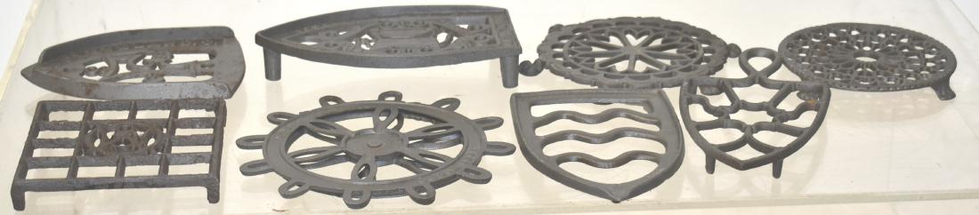 Collection of Vintage Trivets: Largest measures approx. 7" in length. It is an "Uneedit" gas iron trivet. Lot also includes two round footed trivets and other trivets. Total of eight pieces.