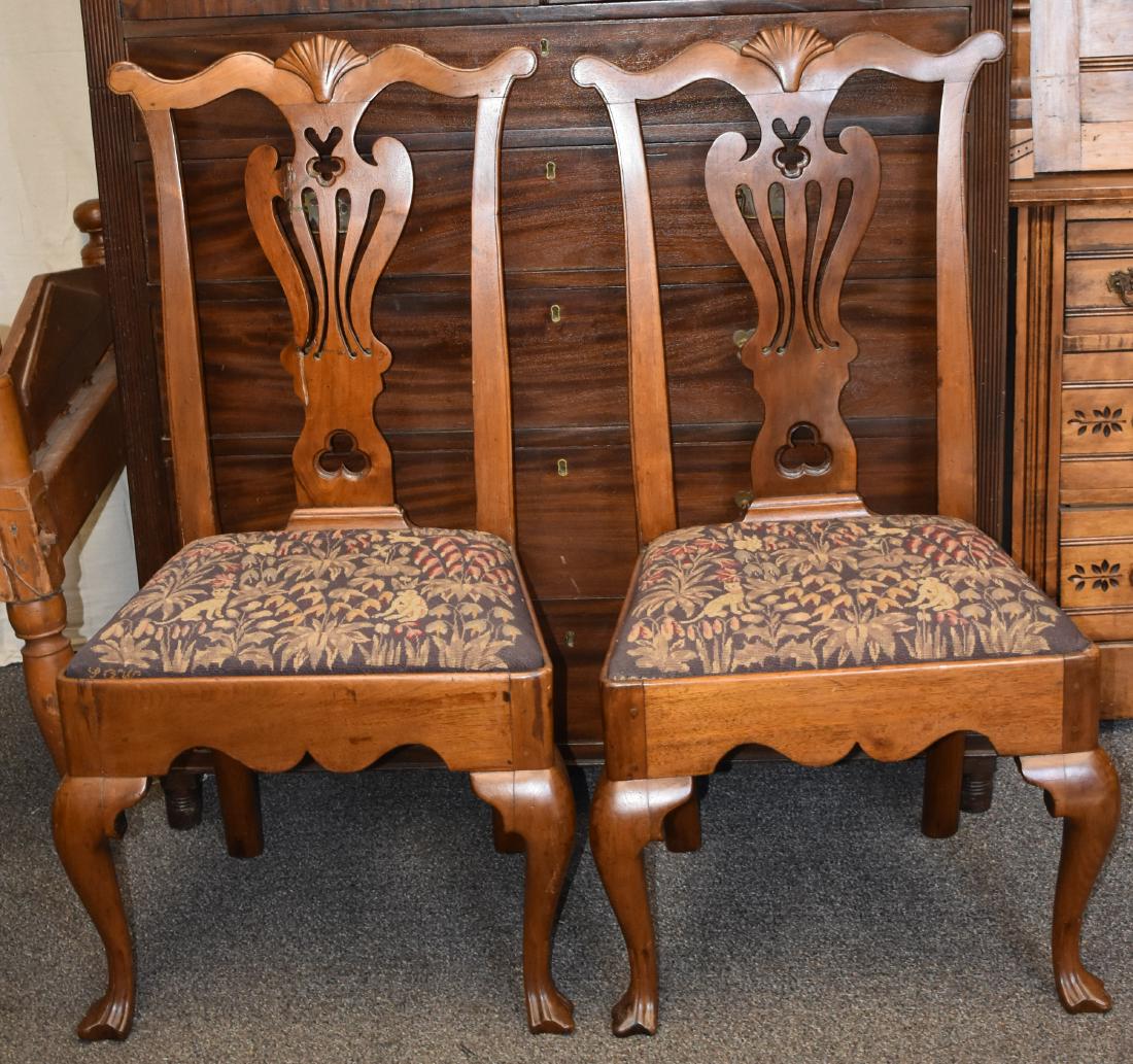 Pair of Philadelphia Walnut Chippendale Chairs: Chairs both measure approx. 40"h. They have shell carved finials, decorative cut out splats and a hand hewn frame with a scalloped front. Frame is mortised through the back. Chairs have wood peg const