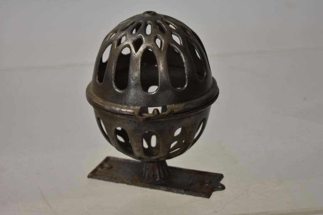 19th Century String Ball Holder: Item measures approx. 7 1/2"h. It is a cast iron string ball holder with original bracket and a sand blasted surface. Item appears to be complete.