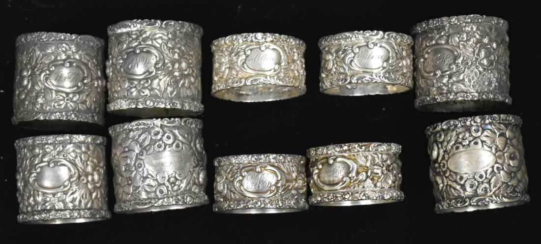 Ten Floral Stieff Sterling Napkin Rings: Six measure approx. 1 1/2"h and are in similar floral patterns and one is dated 1905. Four measure approx. 1"h and are in similar floral patterns. Eight of ten are monogrammed.