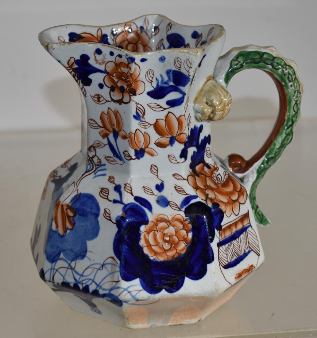 Gaudy Ironstone Snake Handled Pitcher: Item measures approx. 7 1/2"h. It has a drape variation pattern, a snake handle with a lion's head. a few rubs around the opening.