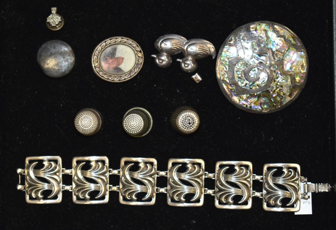 Mixed Silver Grouping: Including a decorative bracelet, three thimbles, a Mexican sterling pin with inlay, a sterling duck pin and various other items.
