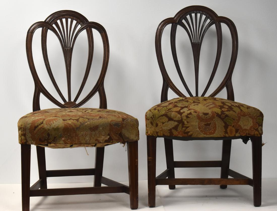 Period Hepplewhite Shield Back Chairs (2): The have heavily carved shield backs. Each back has a repair. They have crewel work seats and reeded legs. Each measures approx. 36 1/2"h.