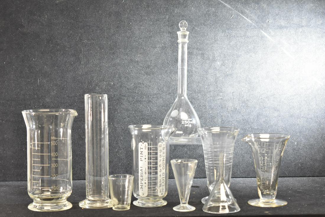 Beakers and Scientific Items: Lot includes an "Imperial" pint beaker, a Pyrex beaker with a stopper, a funnel and other related items. Nine total items.