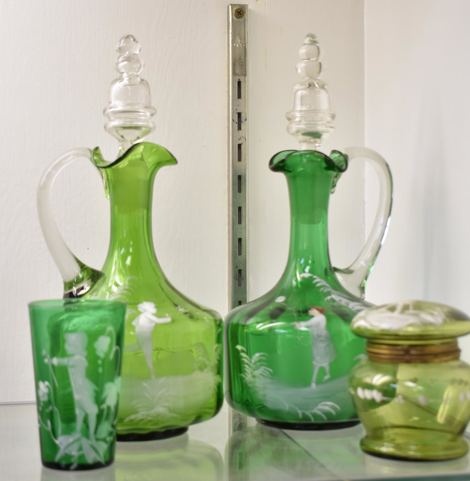 Collection of Green Mary Gregory Glass: Including two Cruets measuring 11" high each, a covered jar, and a tumbler