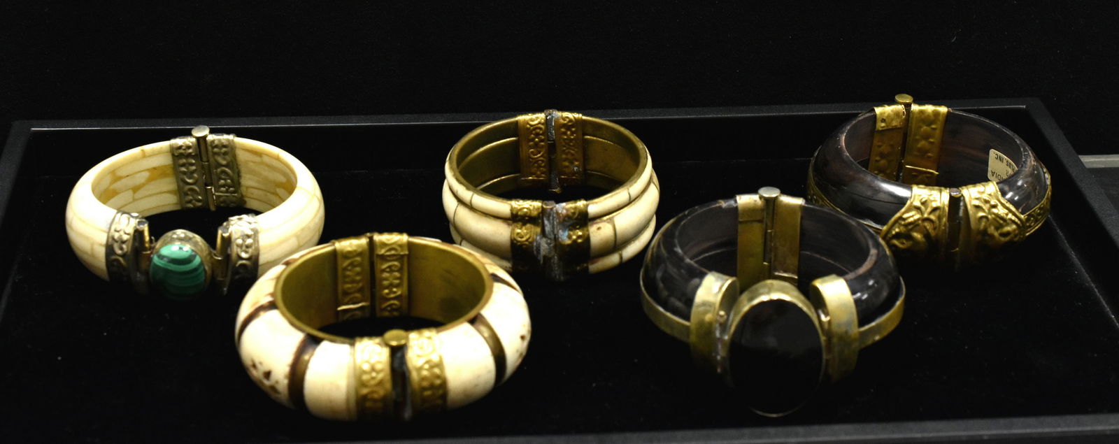 Five Indian Bone and Stone Bangles: Two black bone bangles, two with no stones but one with flower design, and one semi-precious green /malachite stone. All hinged with post closures, made in India.
