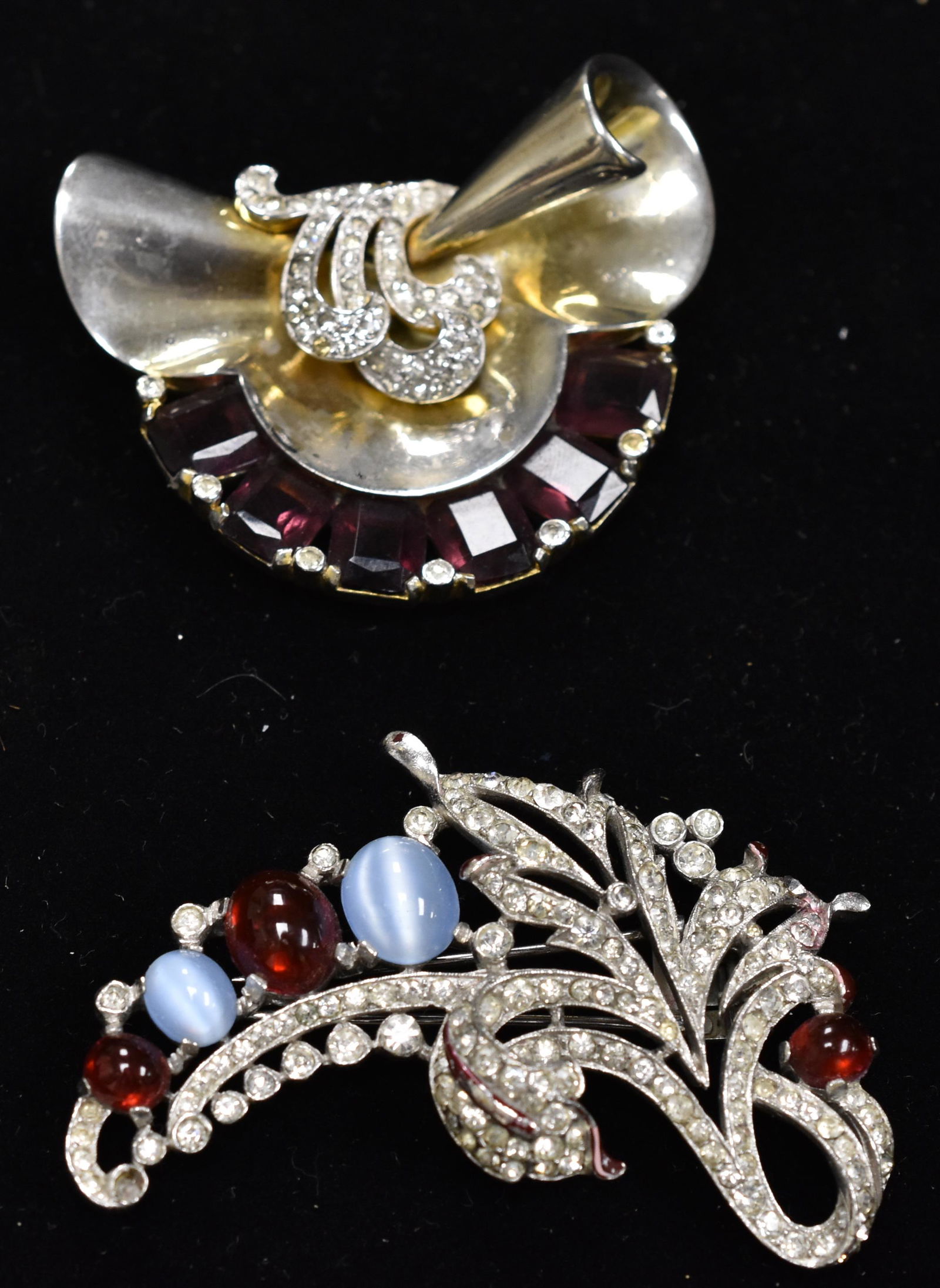 Mazer and Trifari Fur Clips (2): Mazer clip with clear and amethyst stones and Trifari clip with red, blue and clear stones.