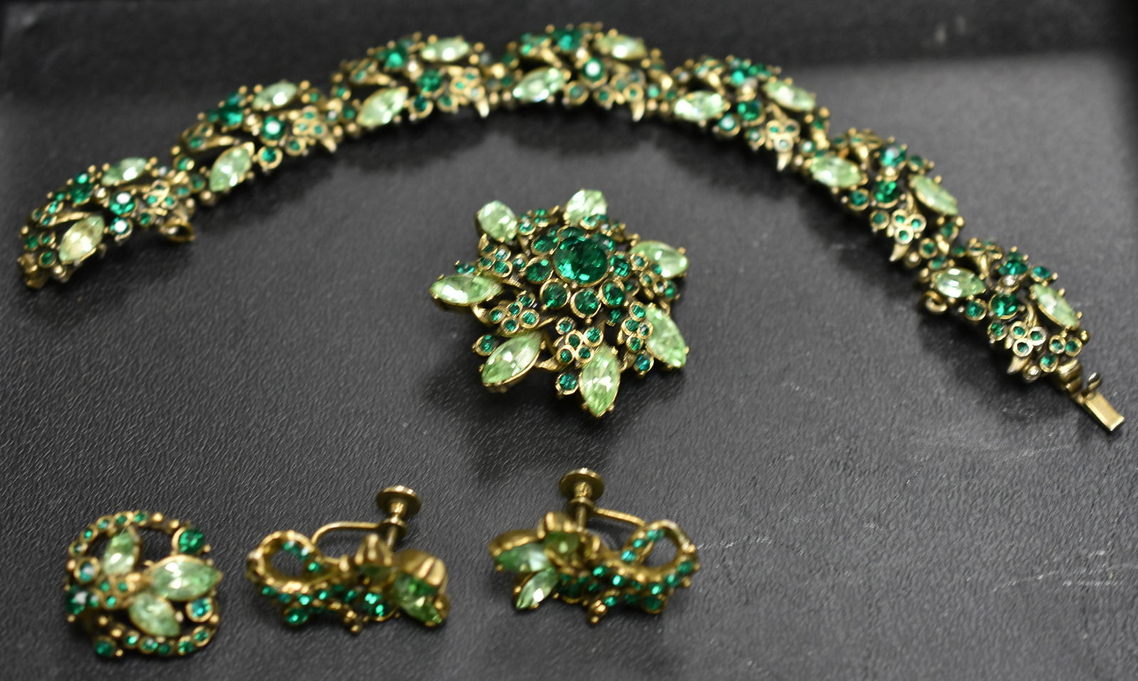 Green Hollycraft Four Piece Rhinestone Set: including a bracelet, brooch, pin and a pair of screwback earrings all with emerald and pale green rhinestones.